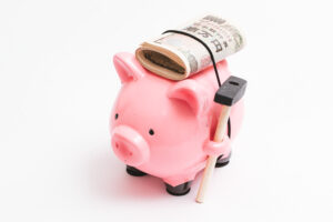 豚の貯金箱に何枚かの1万円札が巻き付けられている